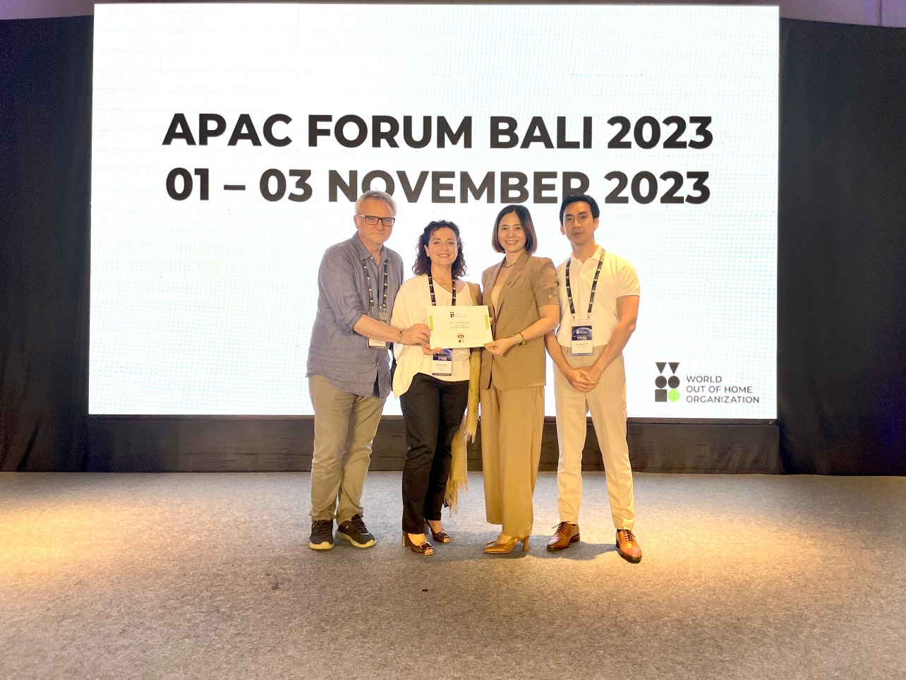 Mark Flys (L) COO and Anna (R, 2nd) Event Director of WOO, hands its membership certificate to Chicilon Media representatives. 